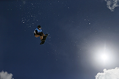 Haciendo Snowboard sobre el cielo azul.